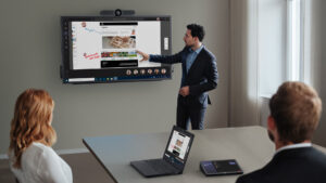 Modern meeting room with presenter using digital whiteboard and Dell collaboration devices
