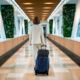 CGI-rendered luggage composited into a retouched stock photo of a woman walking through a modern airport terminal, created by Digital Imaging Group.